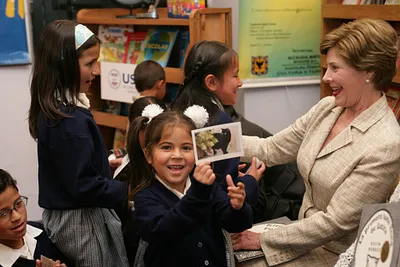 A Little Girl Holds up a Picture of Mrs. Laura Bush's Cat, Willie, in Bogotá, Colombia