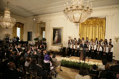 President George W. Bush, Standing with Members of the Jackson High School Black History Tour Group of Jackson, Michigan, Welcomes Guests to the East Room of the White House During the Celebration of African American History Month