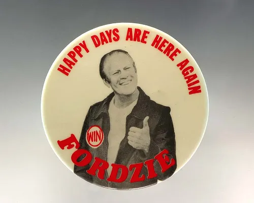 White Campaign Button With Image of President Gerald R. Ford as the Fonz Wearing a WIN Button With the Text “Happy Days Are Here Again Fordzie”