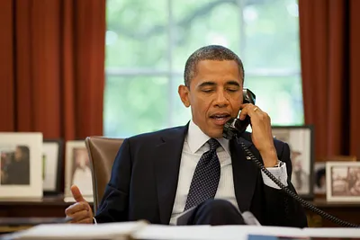 President Barack Obama on the phone in the Oval Office