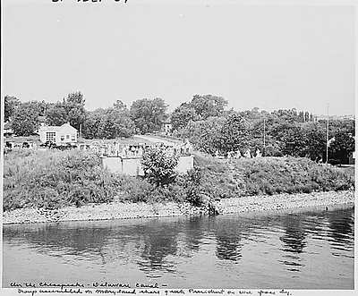 Photograph of spectators assembled on the Maryland shore of the Chesapeake and Delaware Canal to watch President Truman's yacht, the U.S.S. WILLIAMSBURG, pass by on its way to Rhode Island and Bermuda