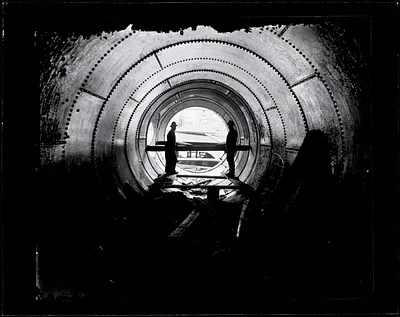 Two workers in a penstock