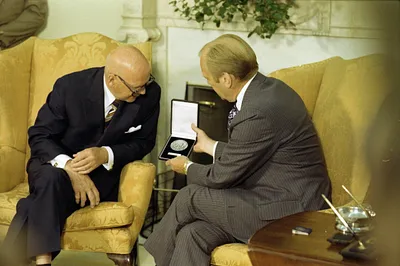 President Gerald R. Ford and President Urho Kekkonen of Finland Examining a Medal Kekkonen Presented to Ford in the Oval Office