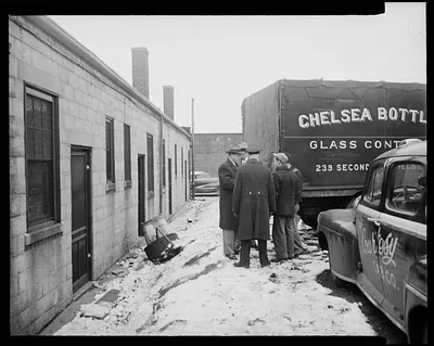 Group of five men standing near a Chelsea Bottle Glass Container truck and Courtesy Cab Co. vehicle