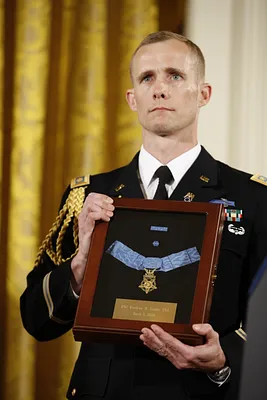 A White House Military Aide Holds the Medal of Honor Presented Posthumously to U.S. Army MSG Woodrow Wilson Keeble