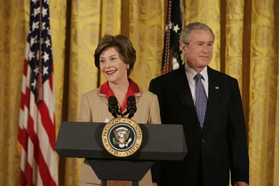President George W. Bush Listens  as Mrs. Laura Bush Welcomes Women Leaders to the East Room on International Women's Day