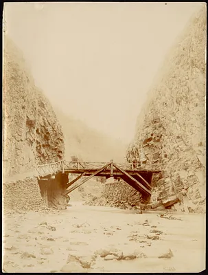 Wooden pedestrian bridge over river in the mountains