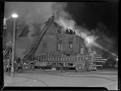 Firefighter crews on top of building with ladders