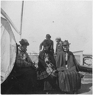 Three men, two women on ship's deck.