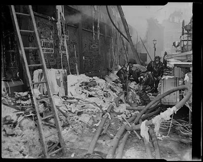 Firefighters amid fire damage to building