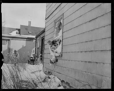 Firefighter holding helmet out of a window
