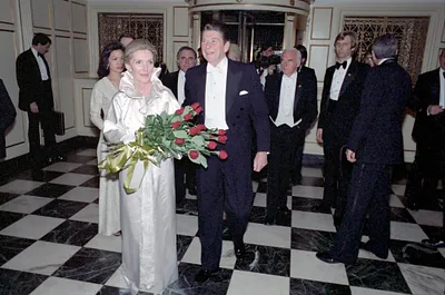 President Ronald Reagan and Nancy Reagan arriving at Kennedy Center Inaugural Ball (Nancy holding roses) with Robert Gray looking on