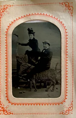 Unidentified man and woman posed on statues of animals