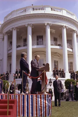 President Gerald R. Ford and Chancellor Helmut Schmidt of the Federal Republic of Germany Standing on a Podium on the South Lawn of the White House While President Ford Delivers Remarks at the State Arrival Ceremony for Chancellor Schmidt