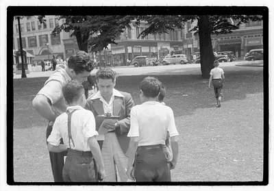 People surround a man holding a clipboard