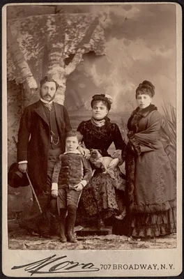 Photograph of three adults with a child and a dog