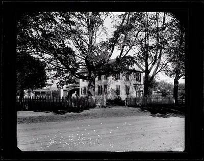 Two-story clapboard house with picket fence