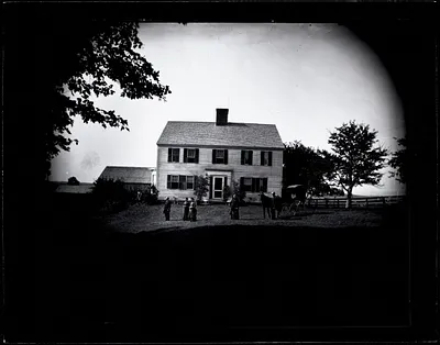 People posed in front of a farmhouse
